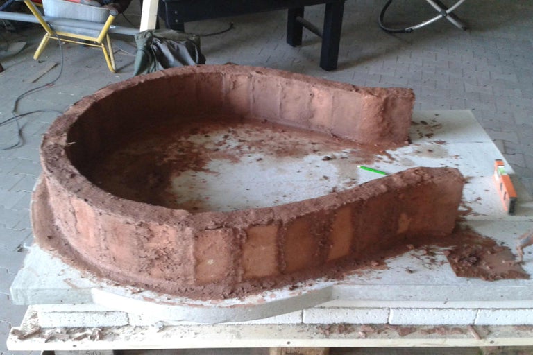 U-förmige Lehmmauer auf Steinen für ein Bauprojekt