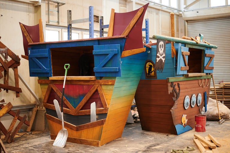 Zwei hölzerne Spielschiffe mit Piratenmotiven und Requisiten