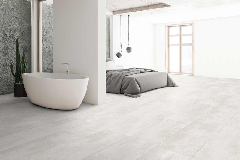 Badezimmer und Schlafzimmer mit freistehender Badewanne und Bodenfliesen