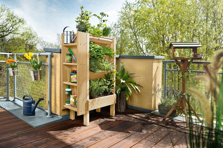Balkon mit Hochbeet, Vogelhaus, Blumenkästen und Gießkanne