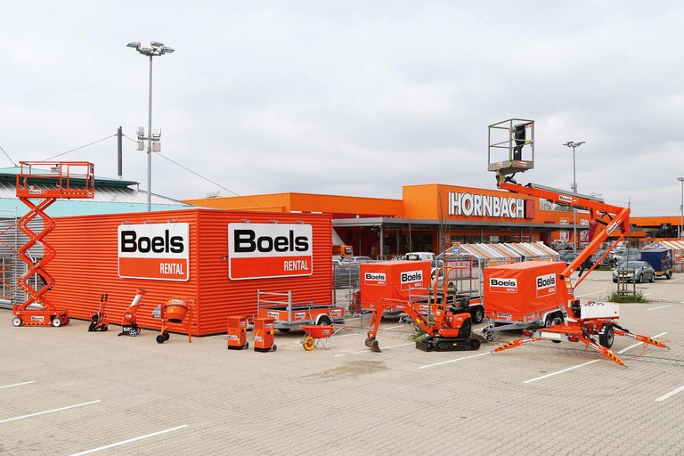 Eine Auswahl an Mietgeräten von Boels Rental vor einem Hornbach Baumarkt.