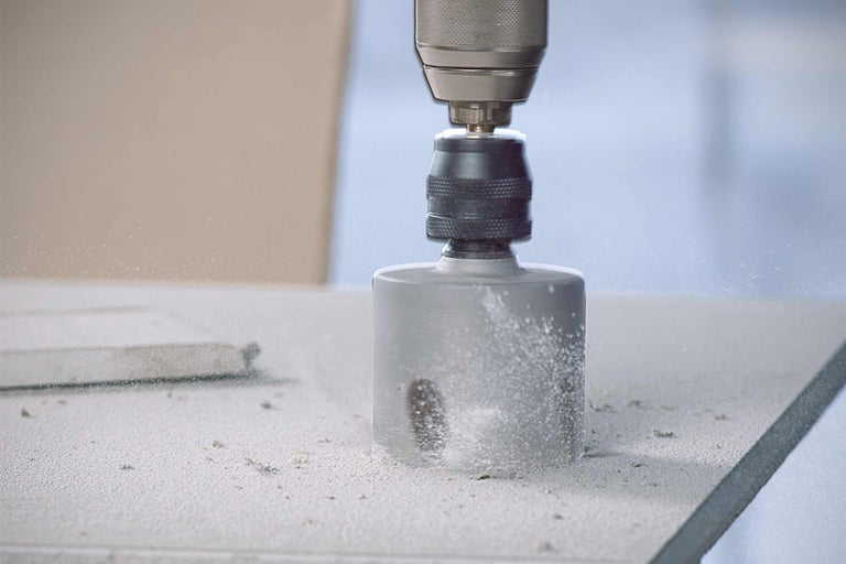 Bohrmaschine mit Lochsäge bohrt ein Loch in eine Oberfläche.