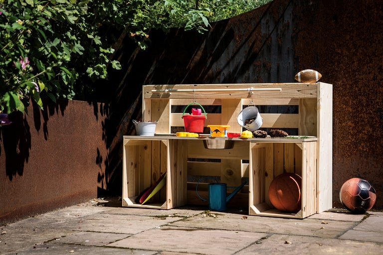 Spielküche aus Holz mit Spielzeug im Garten