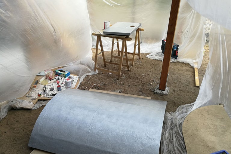 Szene mit Werkzeugen und Materialien in einem mit Folie abgedeckten Bereich.