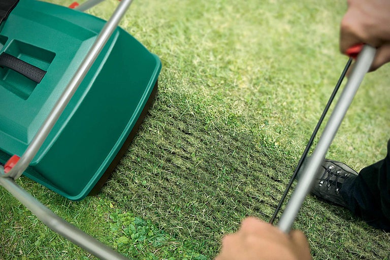 Gartengerät zur Rasenpflege im Einsatz auf einer Rasenfläche.