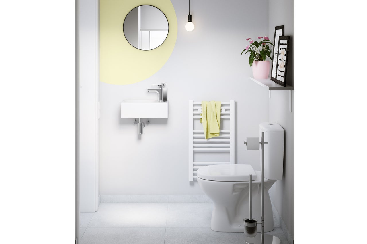 Helles, modernes Gäste-WC mit kleinem Wandwaschbecken, rundem Spiegel, weißem Handtuchheizkörper und bodenstehendem WC.