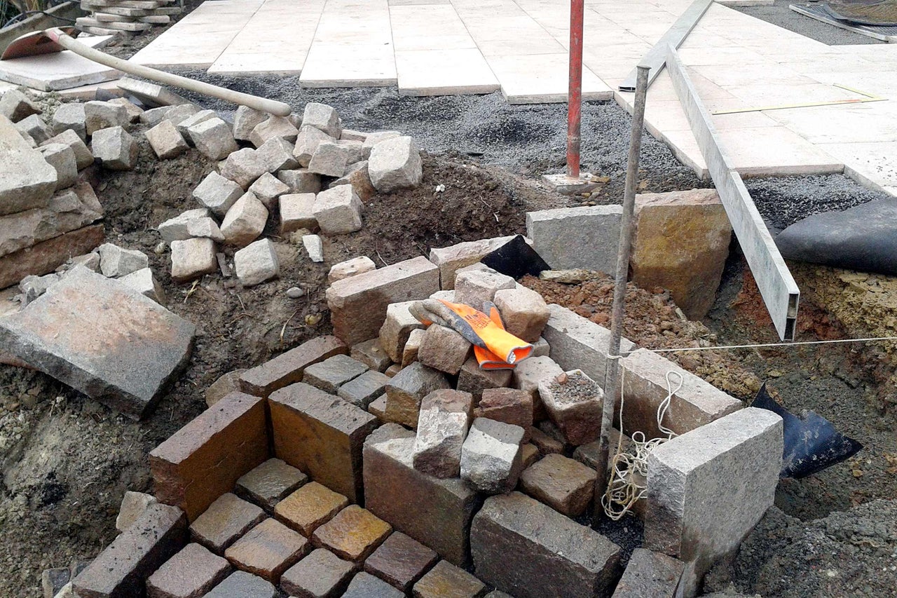 Baustelle mit Pflastersteinen und Werkzeugen für die Gartengestaltung