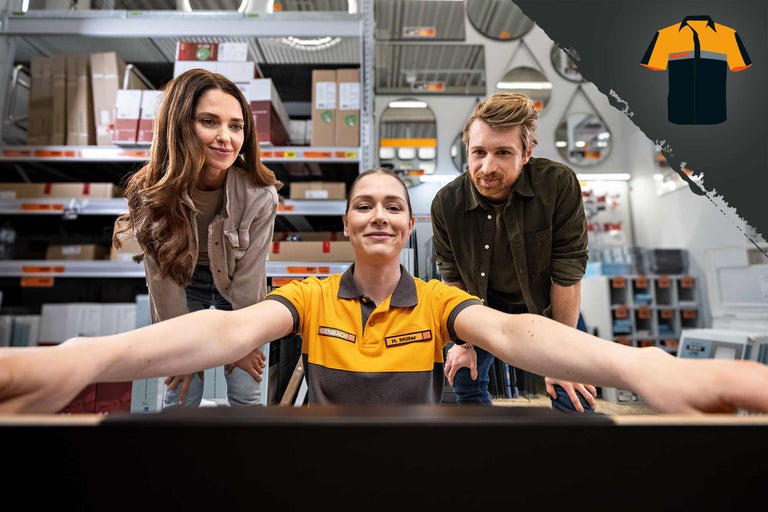 Eine Hornbach Mitarbeiterin und zwei Kunden vor einem Bildschirm im Baumarkt. Im Hintergrund Regale mit Waren.