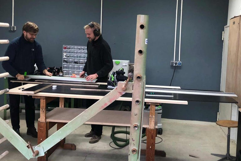 Zwei Handwerker bei der Holzbearbeitung in einer Werkstatt