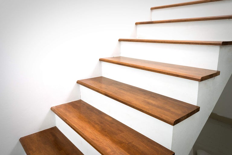 Treppe mit Holzstufen und weißem Treppenhaus
