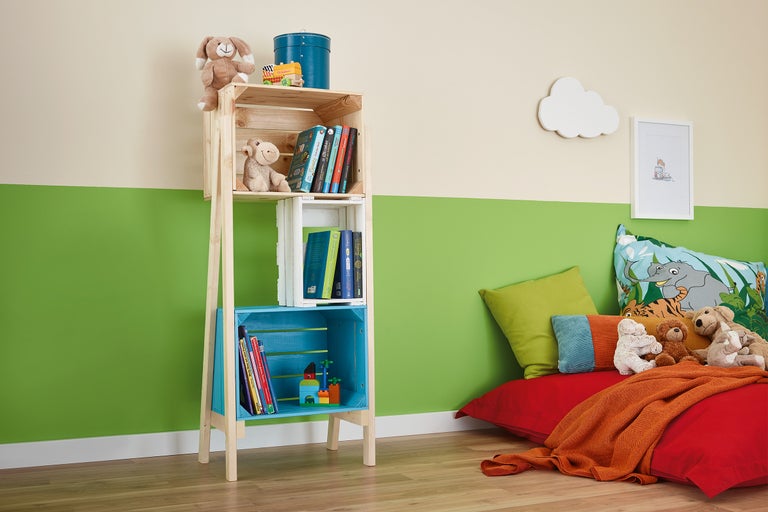 Kinderspielzimmer mit Regal aus Holzkisten, Spielsachen und Kissen