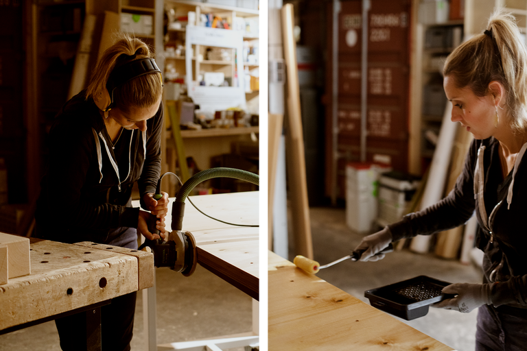 Zwei Frauen arbeiten in einer Werkstatt, eine schleift Holz, die andere streicht es.