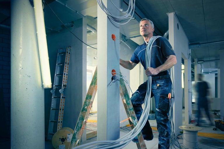 Elektriker bei der Kabelinstallation in einem Rohbau