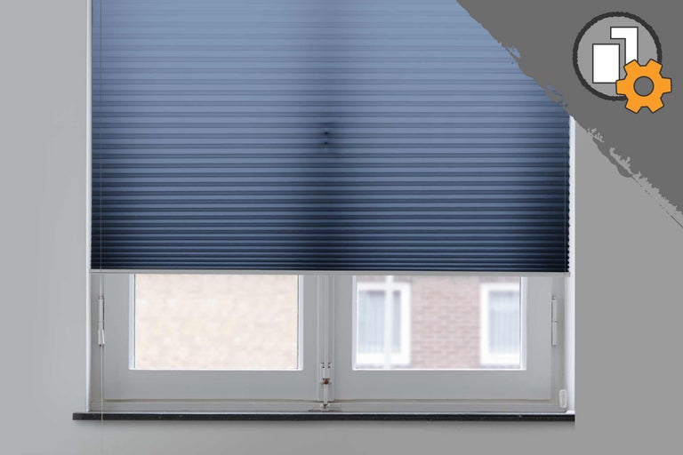 Blaues Plissee am Fenster zur Lichtregulierung