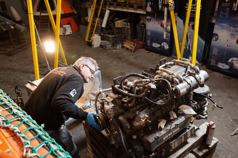 Mann arbeitet an einem Yanmar Motor in einer Werkstatt