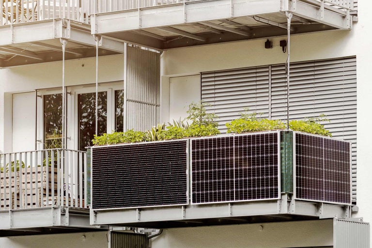 Balkon mit Solarmodulen und Pflanzenkasten