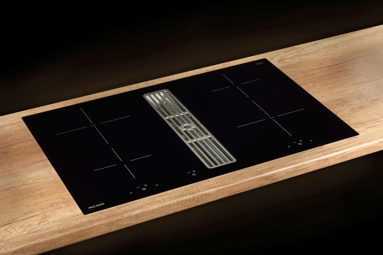Schwarzes Induktionskochfeld mit integriertem Dunstabzug auf einer Arbeitsplatte
