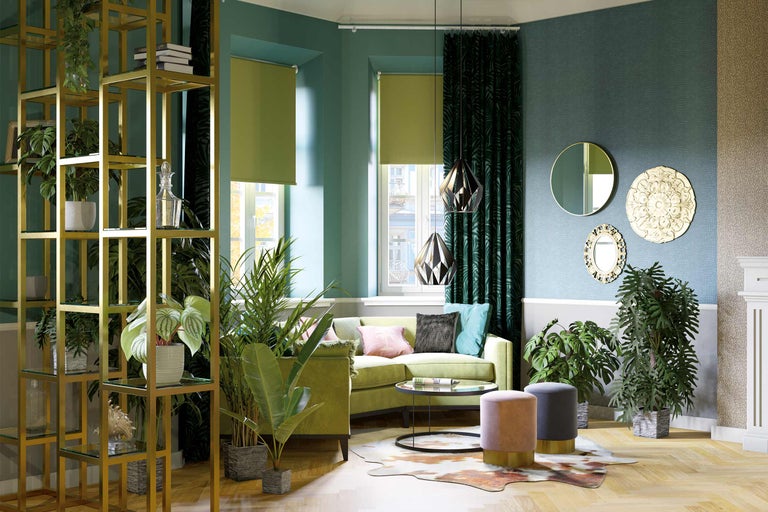 Wohnzimmer mit grüner Couch, Pflanzen, Regalen und dekorativen Elementen für eine lebendige Atmosphäre