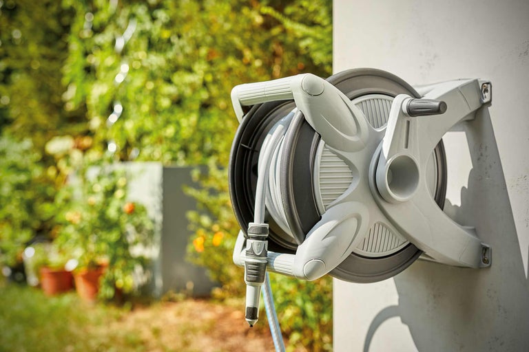 Auf einer Wand montierte Gartenschlauchbox mit Schlauch