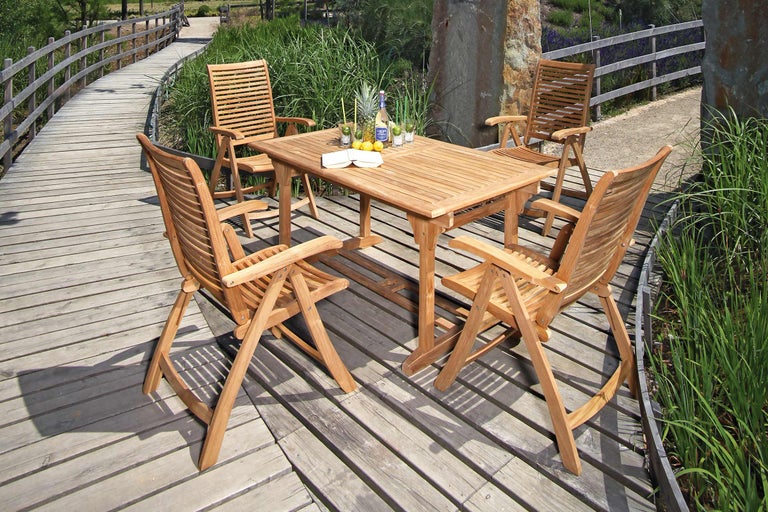 Gartenszene mit Teakholztisch und vier Stühlen auf Holzterrasse