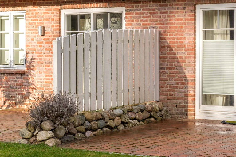 Holz Sichtschutzzaun mit Steinmauer vor einem Backsteinhaus
