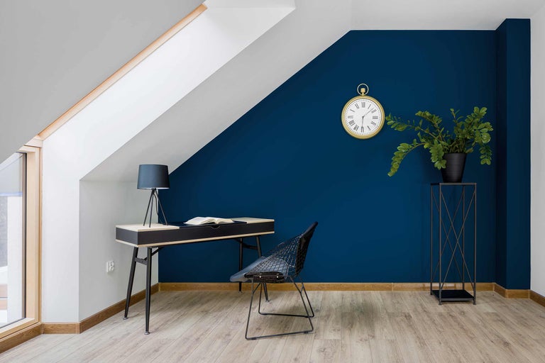 Modernes Arbeitszimmer mit Schreibtisch, Stuhl, Uhr und Zimmerpflanze