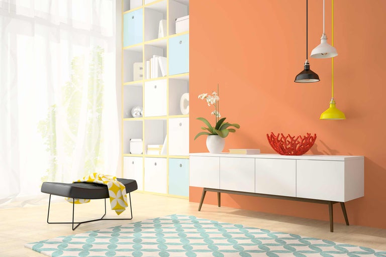 Wohnzimmer mit Regalen, Sideboard, Teppich, Hocker und Pendelleuchten