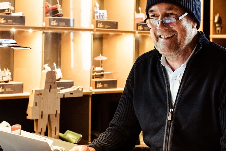 Freundlicher Hornbach Mitarbeiter hinter der Kasse mit Dekoartikeln im Hintergrund.