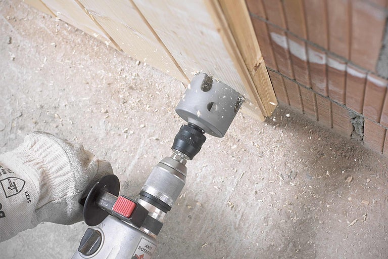 Eine Lochsäge bohrt ein Loch in ein Holzbrett.