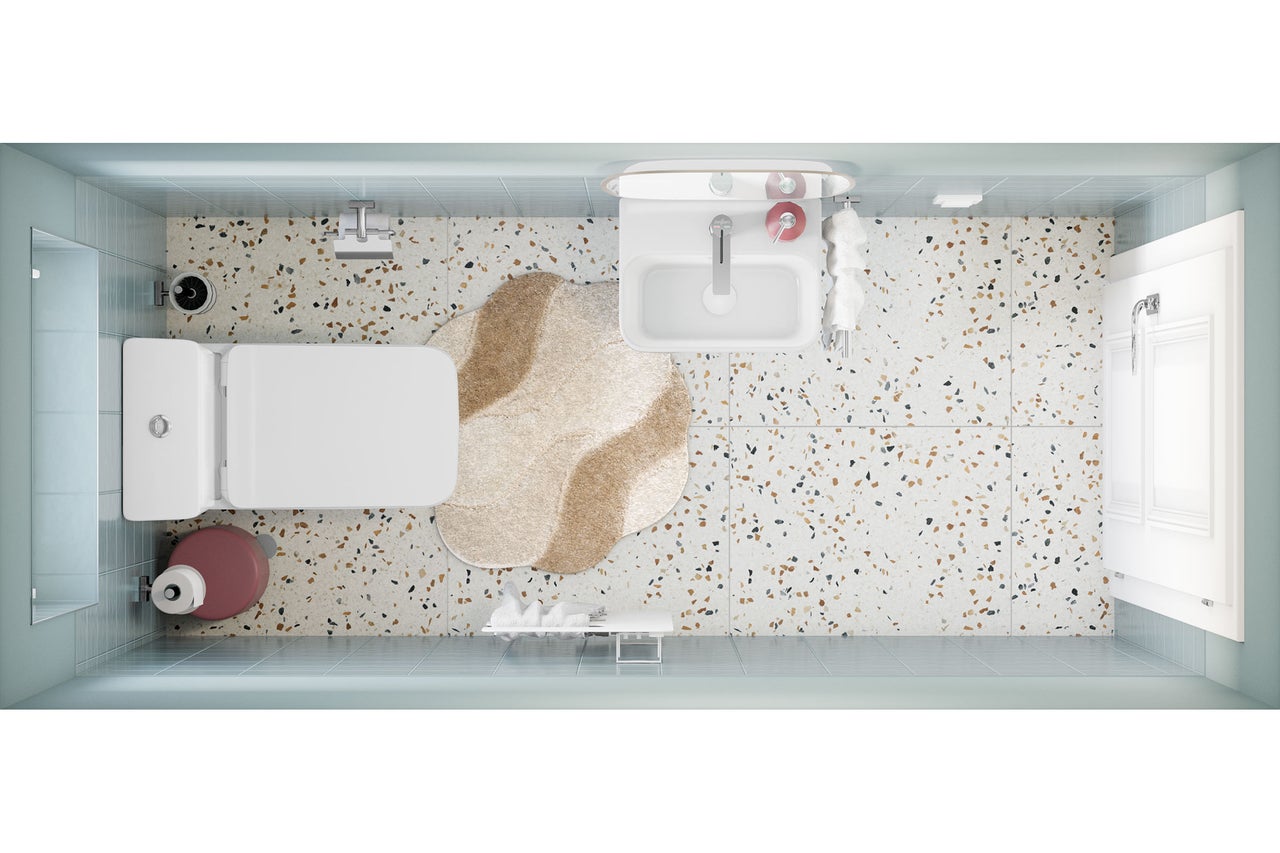 Draufsicht auf ein helles, modernes Badezimmer mit Terrazzoboden, hellblauen Wandfliesen, Waschbecken, Toilette und einem unregelmäßig geformten Teppich.