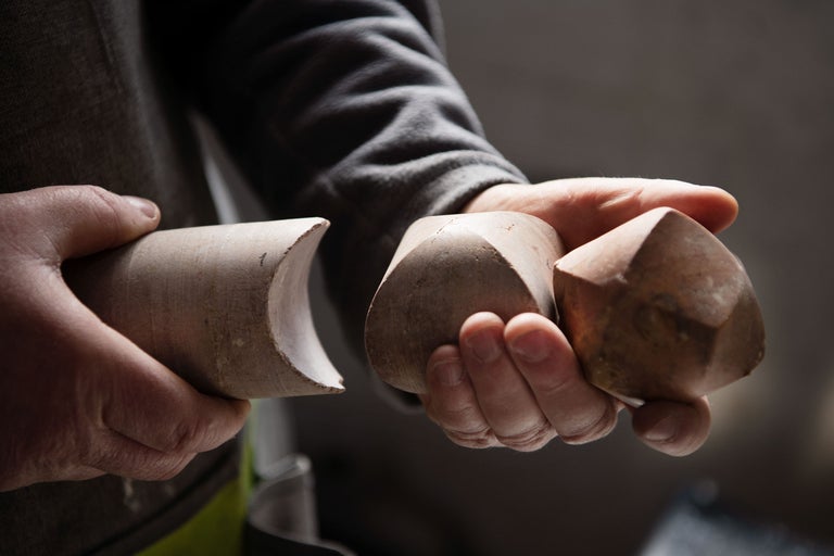 Eine Person hält Holzschraubenformen in der Hand.