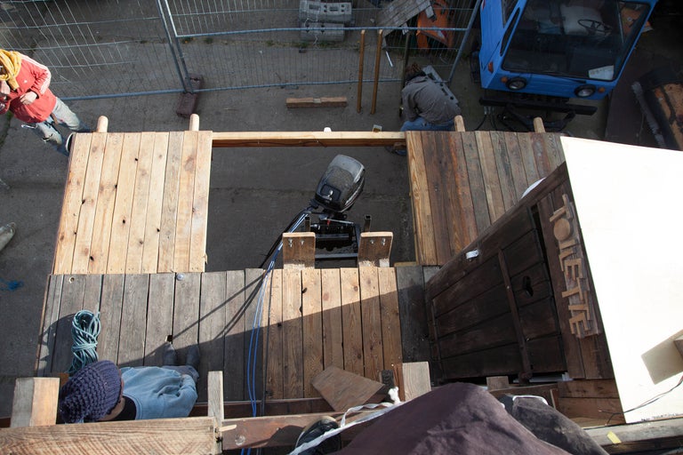 Draufsicht auf ein im Bau befindliches Holzboot mit Außenbordmotor und Toilette