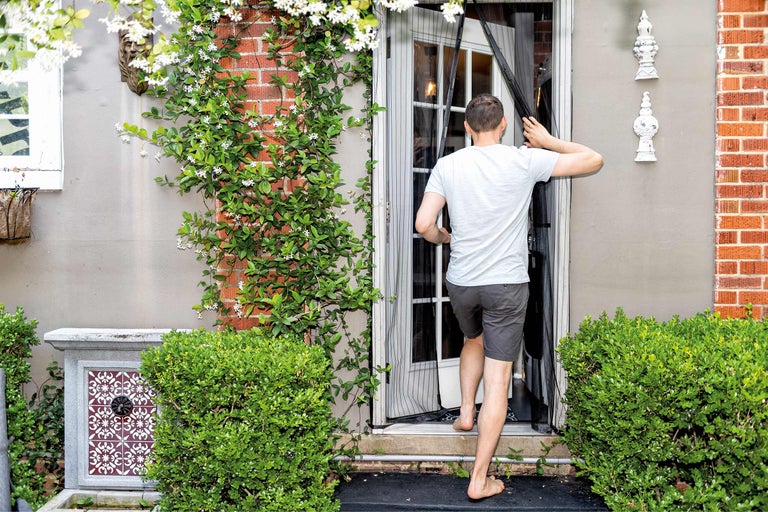 Mann betritt Haus mit Insektenschutzgittertür