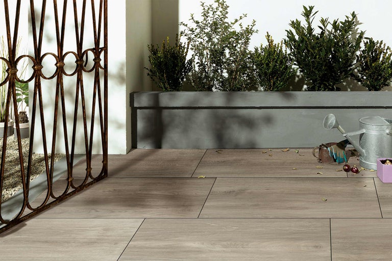 Terrasse mit Holzdielen, Pflanzkasten und Gartenzaun