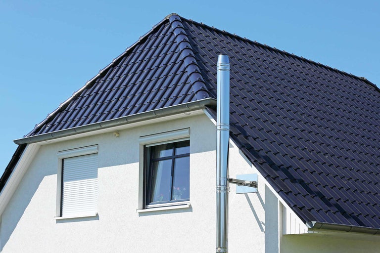 Außenansicht eines Hauses mit Schornstein und Dachziegeln