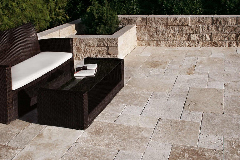 Terrasse mit Rattansitzgruppe, Tisch und Travertin Pflastersteinen