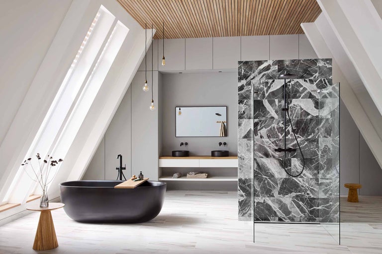 Helles Badezimmer mit Dachschrägen, schwarzer Badewanne, Waschtisch mit zwei Waschbecken, Duschbereich mit Marmorfliesen und Holzelementen