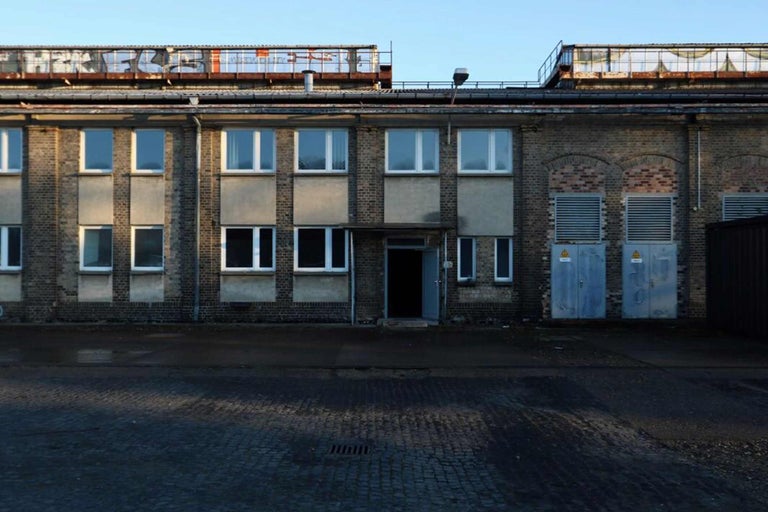 Außenansicht eines Lagerhauses aus Ziegelsteinen mit mehreren Fenstern und Türen