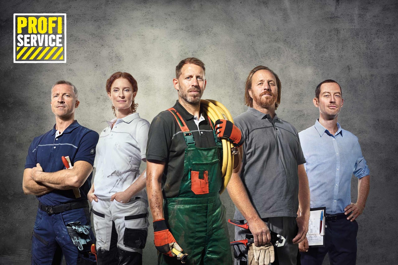 Eine Gruppe Handwerker des Hornbach Profi-Service vor einem grauen Hintergrund