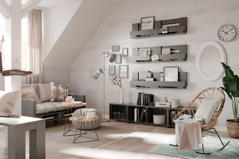 Helles Wohnzimmer mit Sitzgelegenheiten, Regalen und dekorativen Elementen für eine gemütliche Atmosphäre