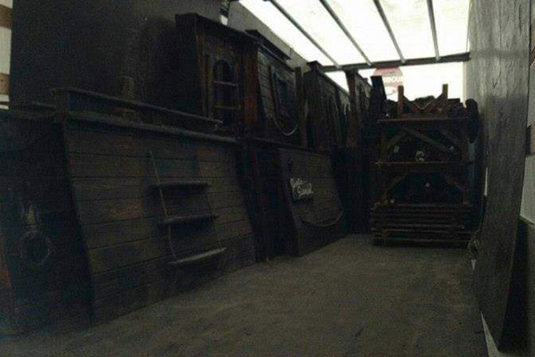 Innenraum mit Holzkonstruktionen, darunter eine Schiffswand mit Leiter