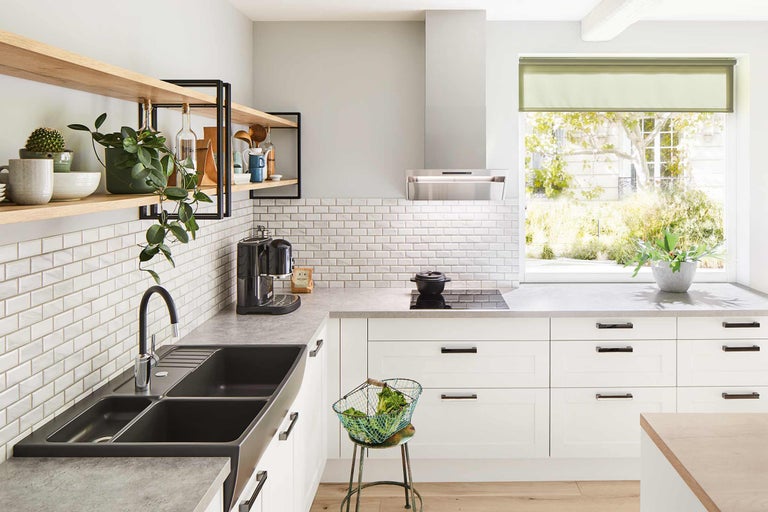 Helle Küche mit Spüle, Kochfeld, Dunstabzugshaube, Fliesen und Regalen