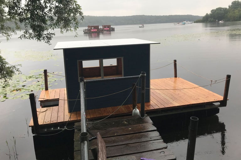 See mit einem Holzhaus auf einem Holzsteg