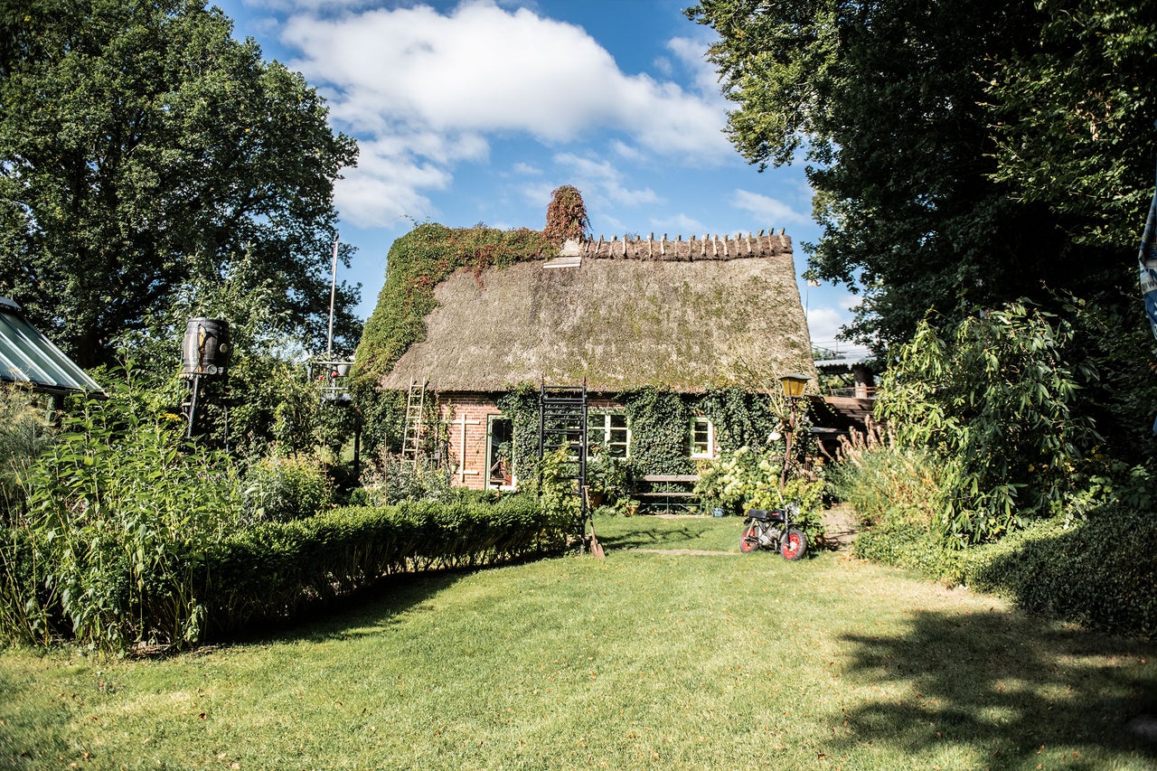 Haus mit Strohdach und Gartenanlage
