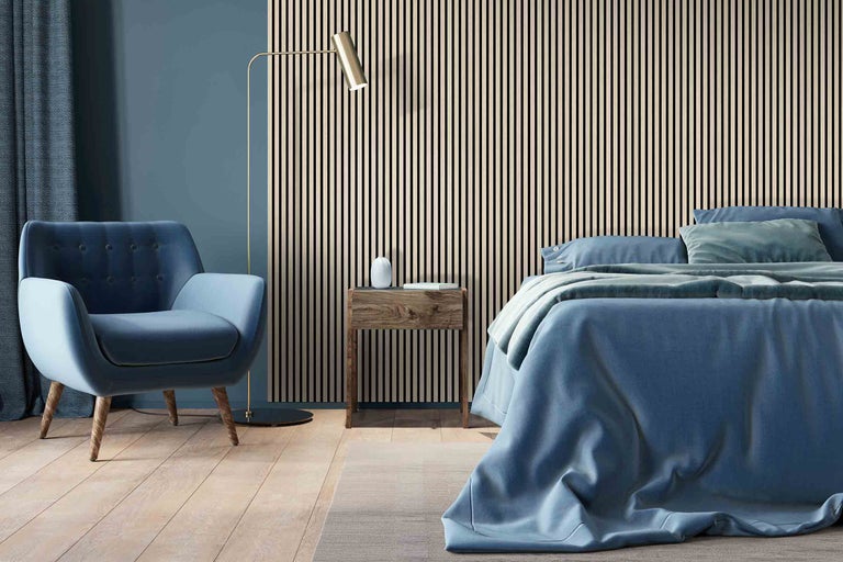 Schlafzimmer mit Bett, Sessel, Stehlampe und Holzpaneelwand