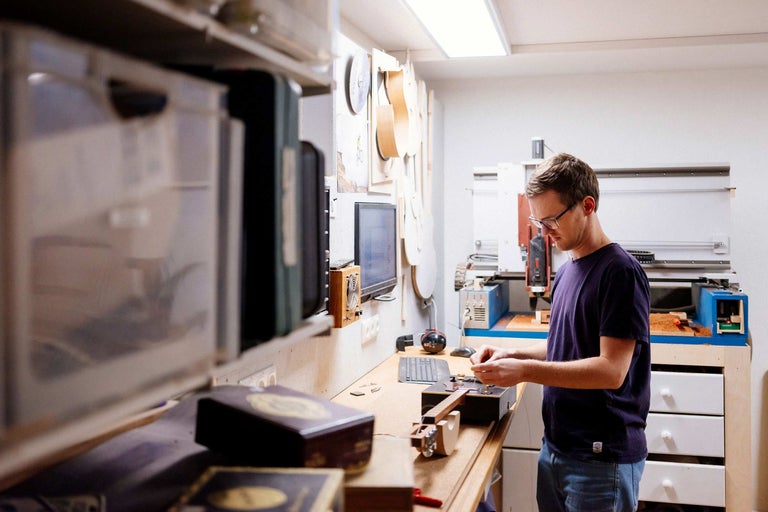Werkstatt mit Mann, der ein Saiteninstrument bearbeitet