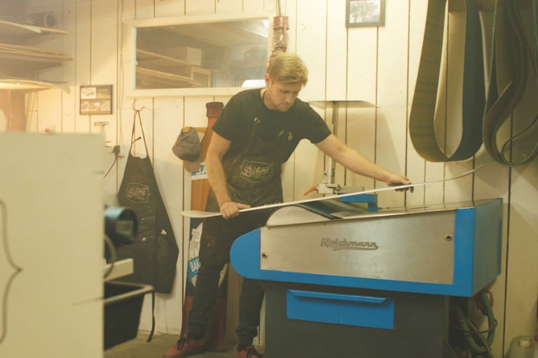 Mann, Werkstatt, Skiservice mit Schleifmaschine und Messwerkzeug