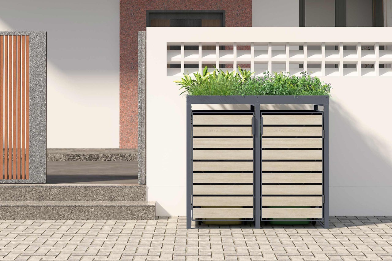 Doppelter Mülltonnenbox mit Pflanzwanne vor einem Haus