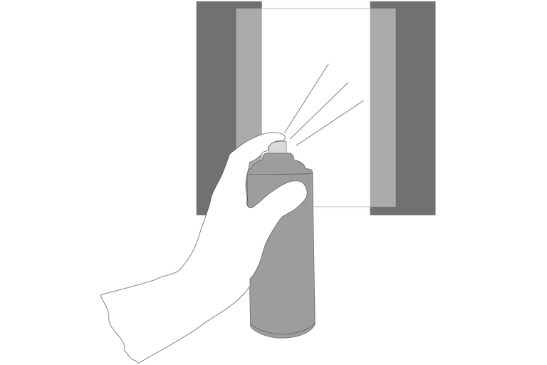 Eine Hand hält eine Sprühdose vor einer mit Klebeband abgeklebten Oberfläche.