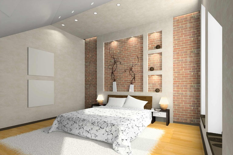 Schlafzimmer mit Doppelbett, Nachttischen und Backsteinmauer